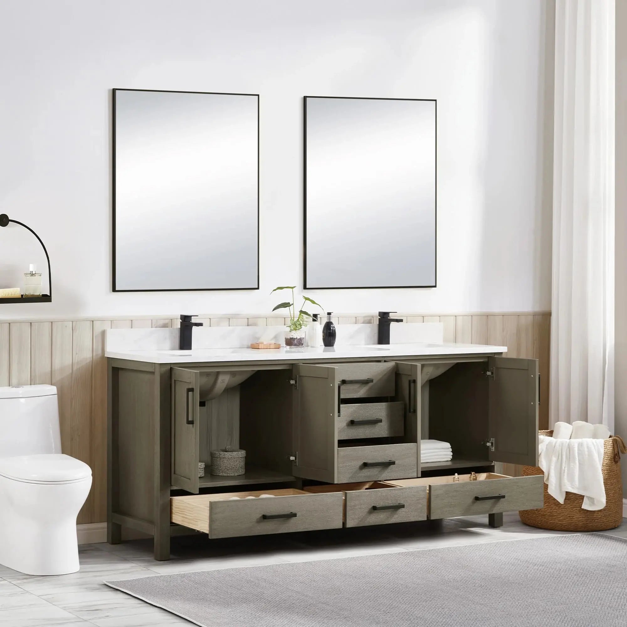 Bathroom vanity with open drawers, two mirrors, and a toilet.
