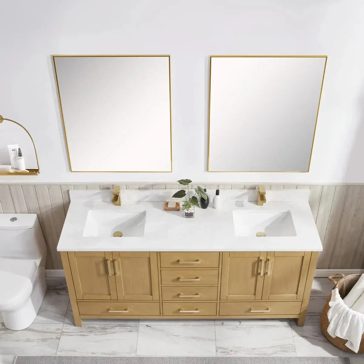Bathroom vanity with double sink, mirrors, and decor items.